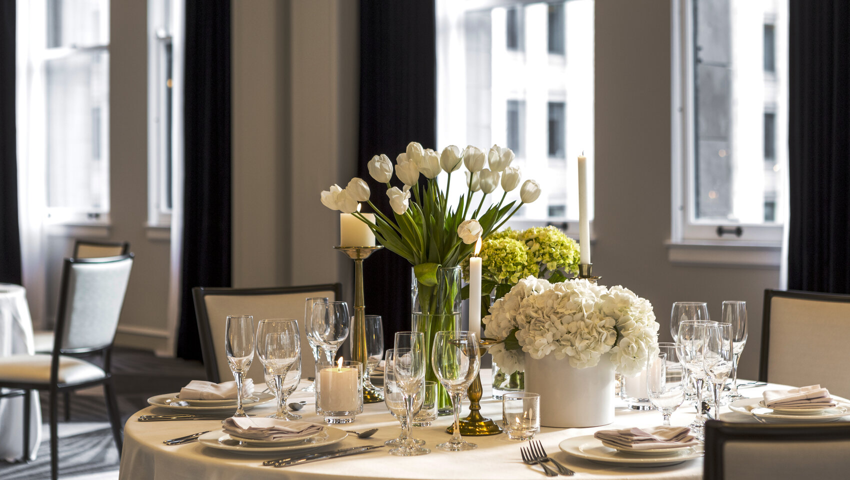 Round dining table set with white flowers and candles